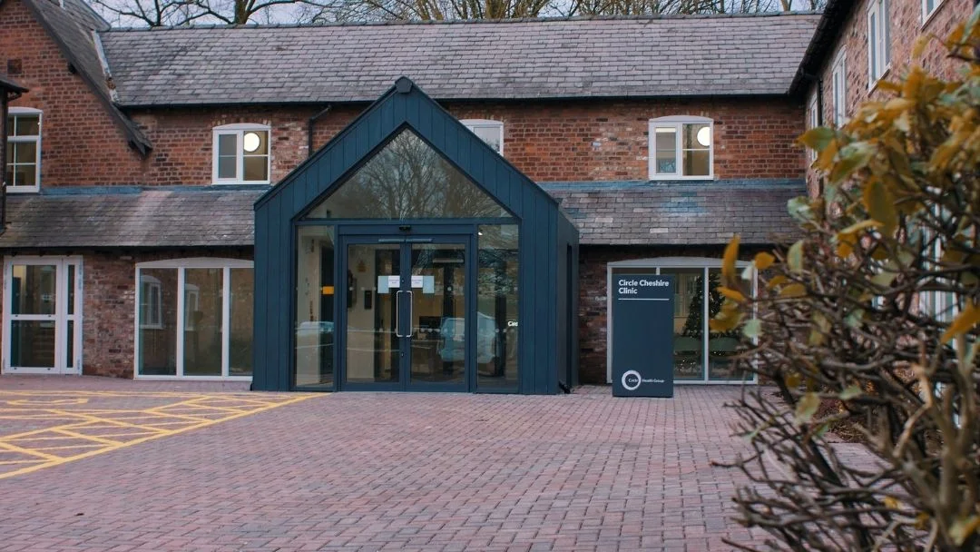 Circle Cheshire Clinic entrance, modern architecture, welcoming atmosphere, Lux Plastic Surgery branding, surrounding greenery, located in Northwich, UK.