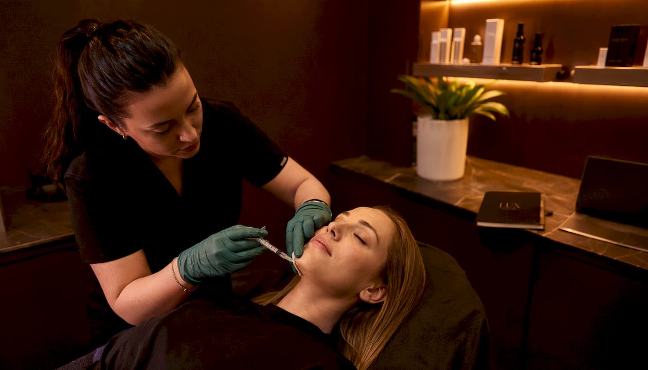 Professional injecting dermal filler into chin
